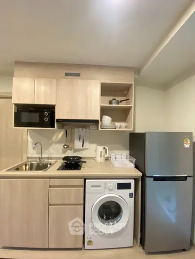 Modern kitchen with washing machine, fridge, and microwave in compact layout
