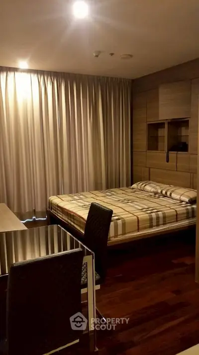 Cozy bedroom with modern furnishings and warm lighting, perfect for relaxation.