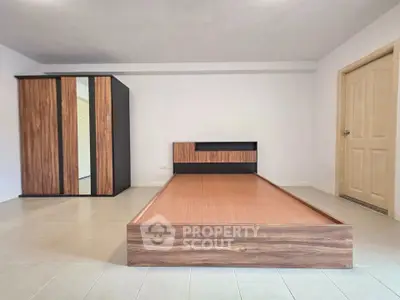 Spacious bedroom with modern wooden bed and wardrobe