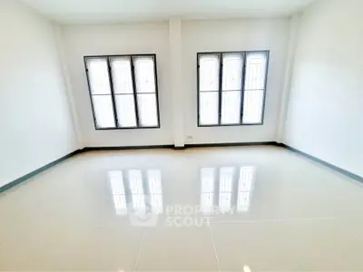 Spacious empty room with large windows and glossy tiled floor, perfect for customization.