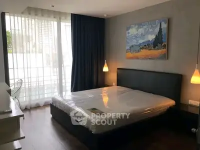 Modern bedroom with large window and stylish decor in a cozy apartment.