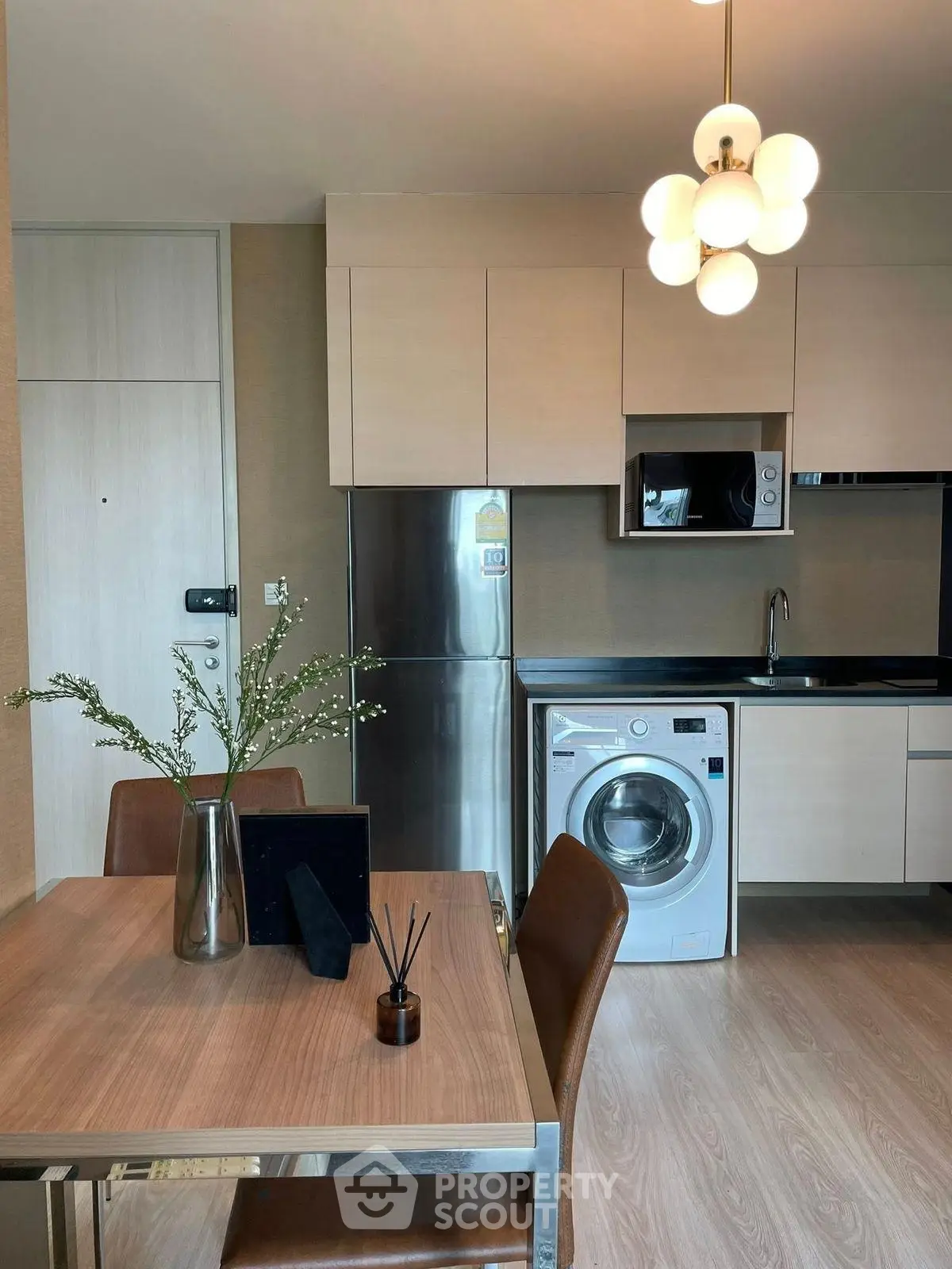 Modern kitchen with washing machine and dining area in stylish apartment
