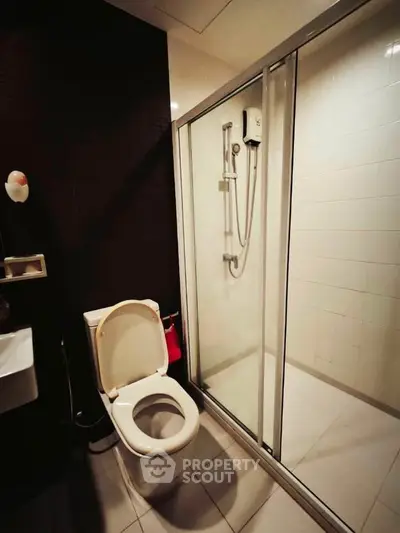 Modern bathroom with glass shower enclosure and sleek fixtures.