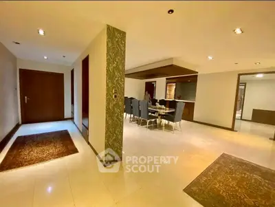 Spacious open-plan living and dining area with modern decor and elegant lighting.