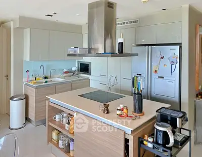 Modern kitchen with sleek cabinetry, island, and stainless steel appliances in a contemporary home.