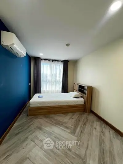 Spacious bedroom with modern design and large window for natural light.