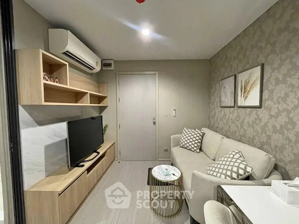 Modern living room with stylish decor and air conditioning, featuring a cozy sofa and entertainment unit.