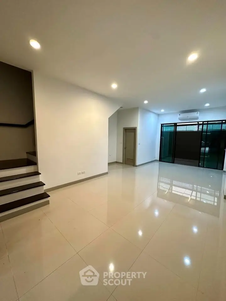 Spacious modern living room with sleek tile flooring and ambient lighting