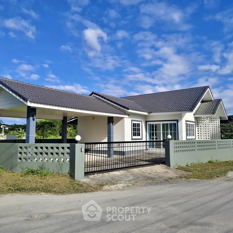 Charming single-story house with modern design and spacious driveway under a clear blue sky.