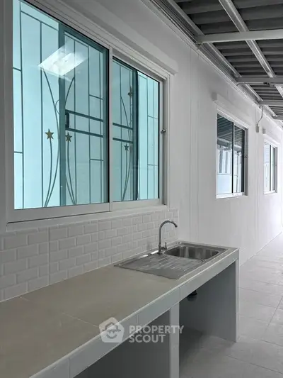 Modern kitchen with sleek sink and large windows in minimalist design