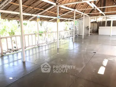 Spacious open-air terrace with rustic wooden roof and natural light, perfect for gatherings or events.