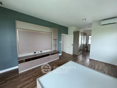 Spacious modern bedroom with built-in storage and sleek wood flooring