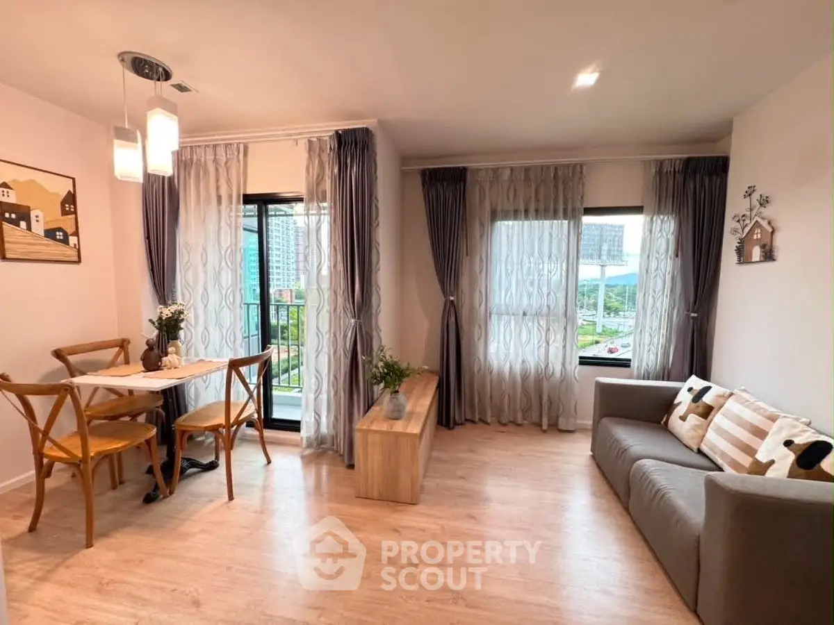 Charming living room with cozy dining area and balcony view, perfect for modern living.