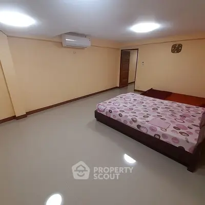 Spacious bedroom with modern air conditioning and minimalist decor.