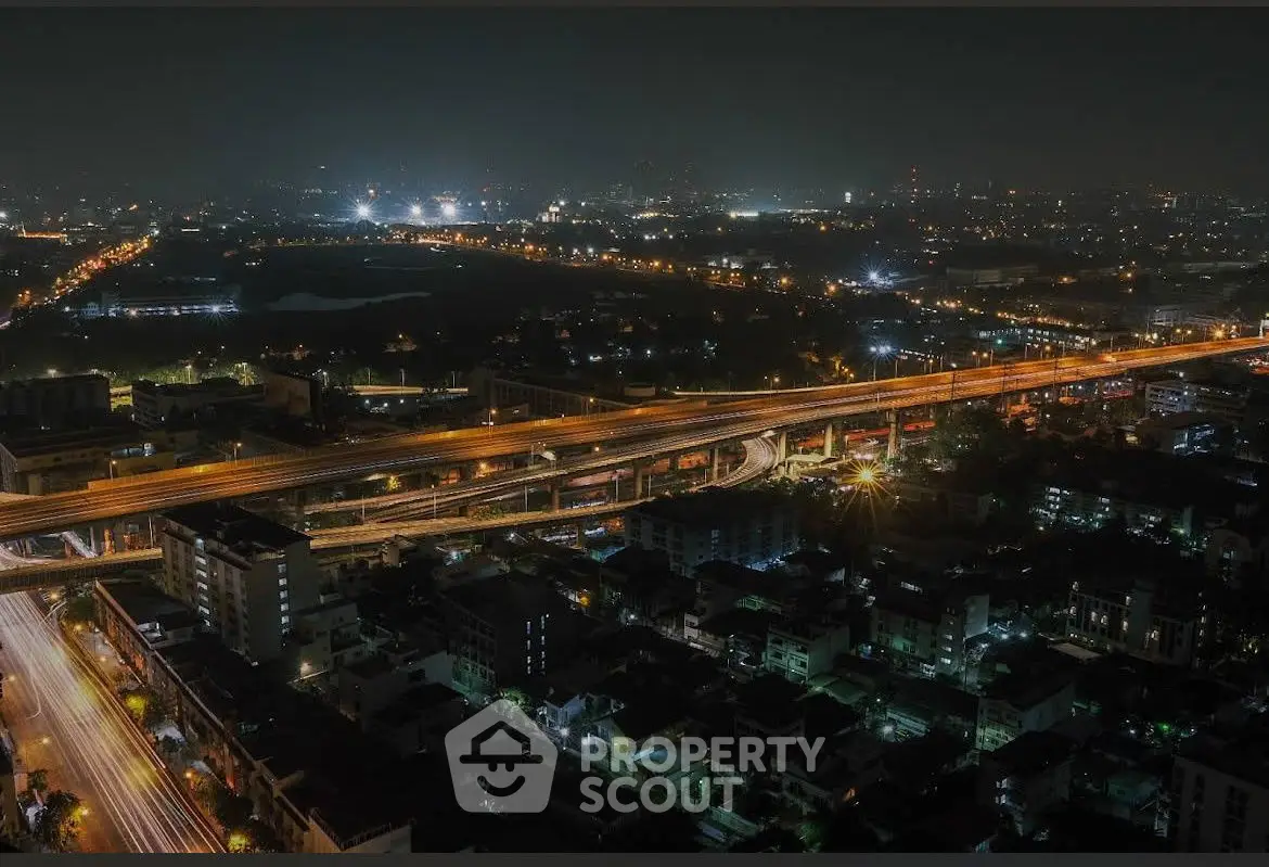 Stunning aerial night view of cityscape with illuminated highways and urban skyline.