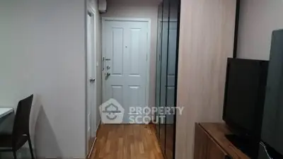 Modern apartment entrance with sleek wooden flooring and mirrored closet