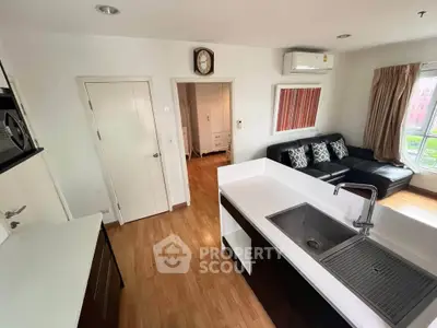 Modern open-layout kitchen and living room with sleek design and natural light.