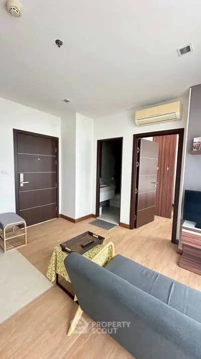 Modern living room with wooden flooring and air conditioning in a stylish apartment.