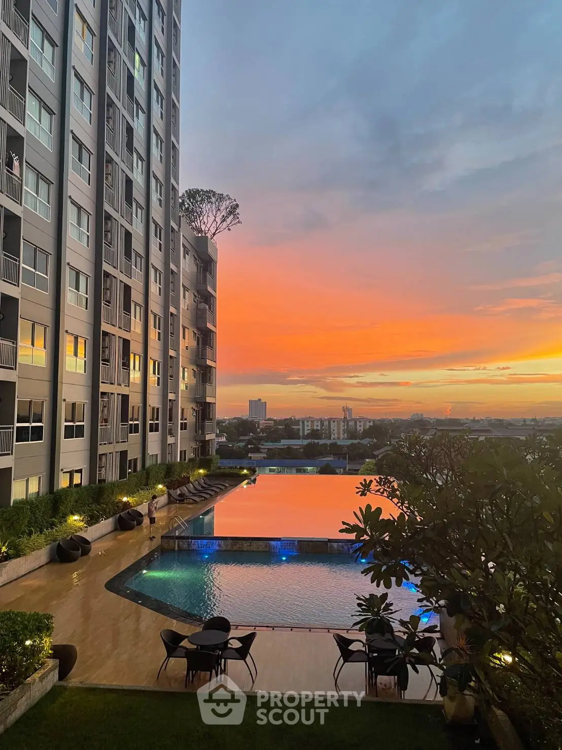 Stunning sunset view from modern apartment building with poolside amenities.