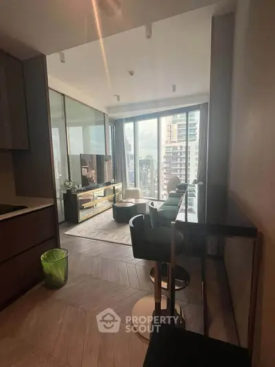 Modern living room with city view, stylish furniture, and floor-to-ceiling windows in high-rise apartment.
