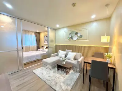 Modern open-plan living room with cozy decor and adjacent bedroom