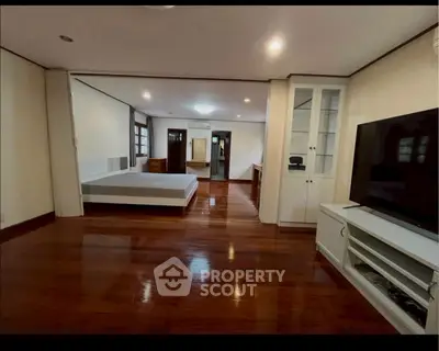 Spacious open-plan living area with wooden flooring and modern furnishings