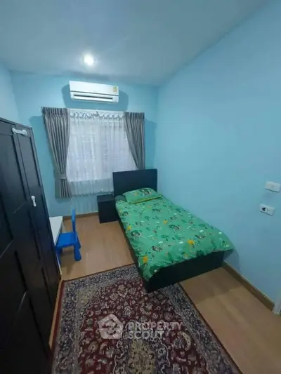 Cozy bedroom with single bed, air conditioning, and vibrant decor.