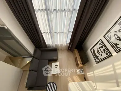 Modern living room with high ceilings, stylish decor, and ample natural light from large windows.