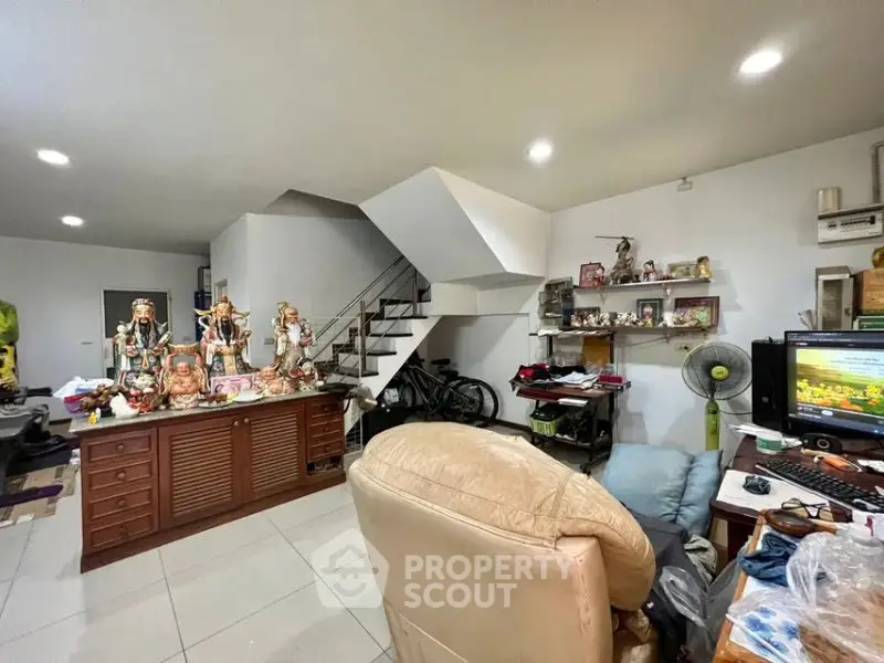 Spacious living room with modern staircase and cozy seating area, perfect for family gatherings.