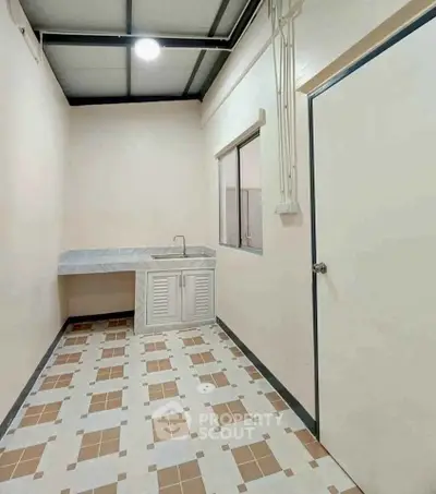Spacious kitchen with modern sink and tiled flooring in a minimalist design.