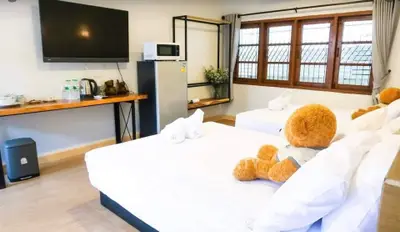 Cozy bedroom with twin beds, large TV, and kitchenette in modern design.