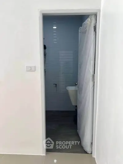 Minimalist bathroom with white walls and simple fixtures, ideal for compact spaces.