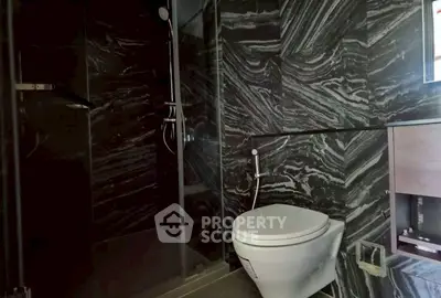 Luxurious modern bathroom with sleek black marble tiles and elegant fixtures.