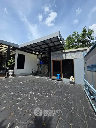 Modern minimalist home exterior with spacious stone driveway and sleek architectural design.