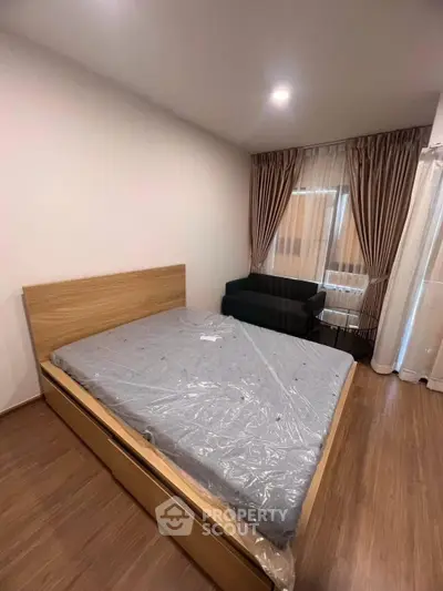 Modern bedroom with wooden flooring, cozy bed, and elegant curtains in a stylish apartment.
