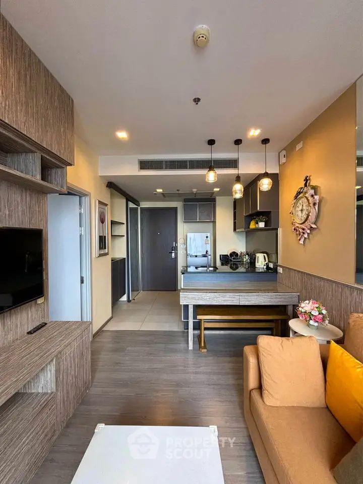 Modern living room with open kitchen, stylish decor, and cozy seating area in a contemporary apartment.