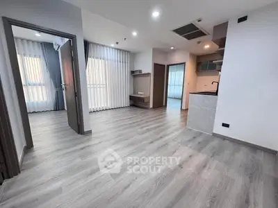 Spacious modern apartment with open layout and sleek flooring, ideal for contemporary living.