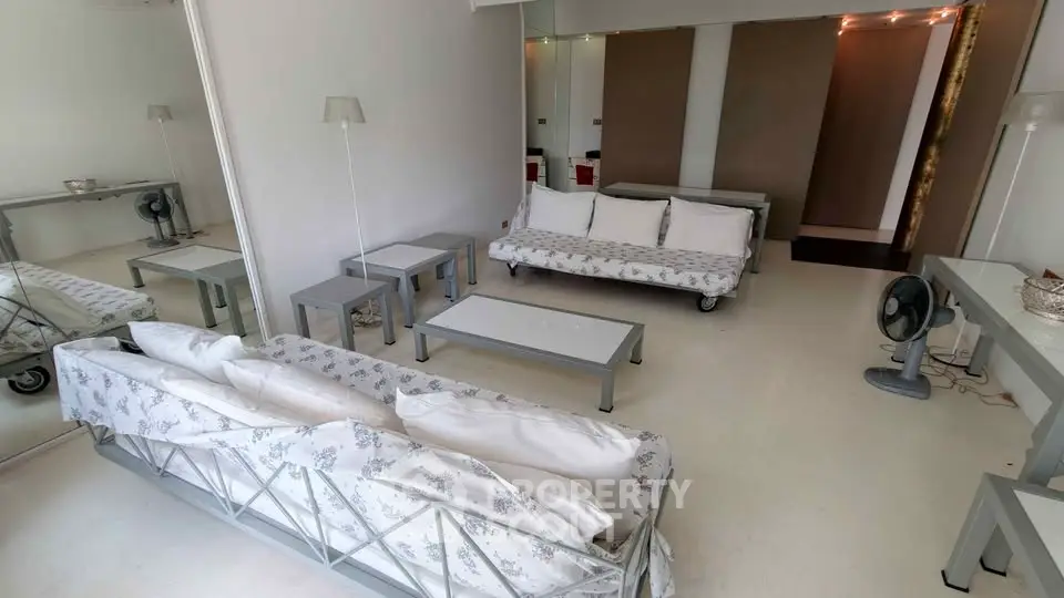 Spacious living room with modern decor and ample seating in a stylish apartment.