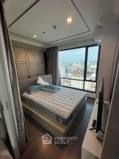 Modern bedroom with city view, featuring large window and stylish decor.