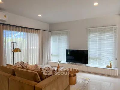 Modern living room with cozy sofa, large TV, and elegant decor