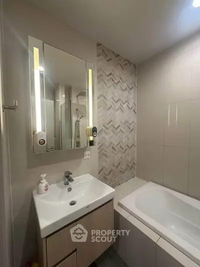 Modern bathroom with stylish vanity and bathtub in contemporary apartment.