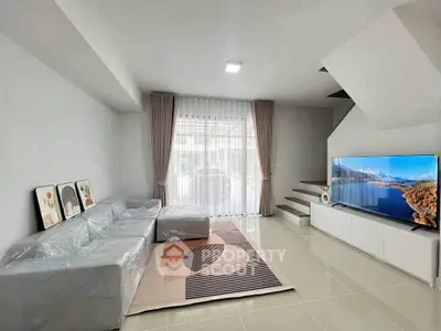 Modern living room with sleek design and large TV, perfect for relaxation.