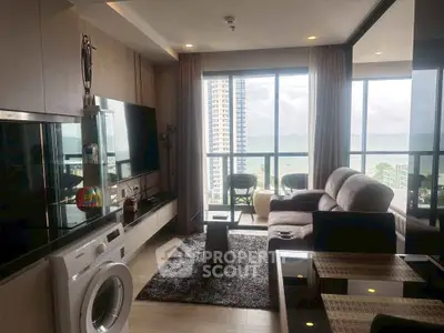 Modern living room with ocean view, featuring sleek furniture and a washing machine, perfect for urban living.