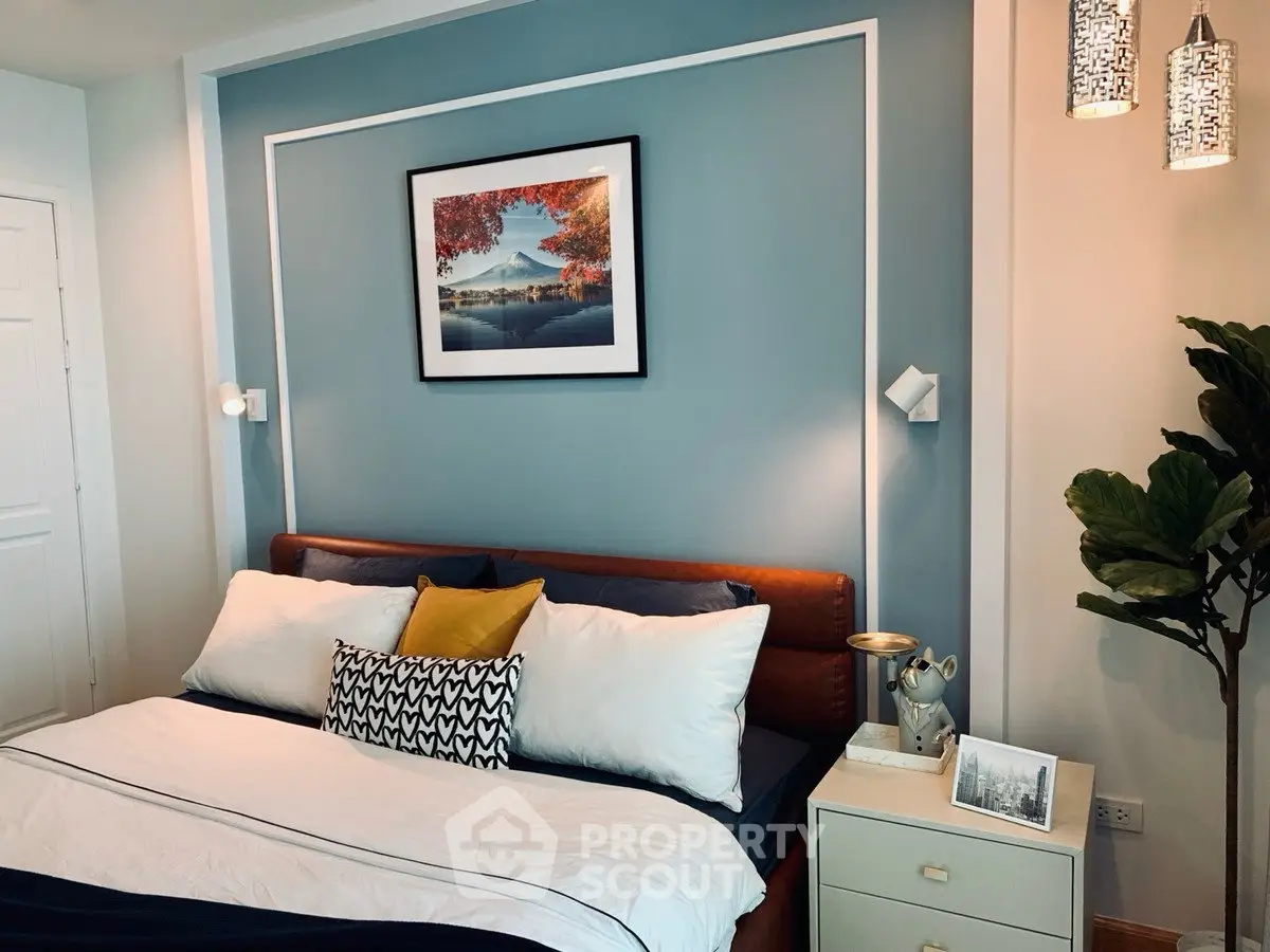 Stylish bedroom with modern decor and cozy ambiance, featuring elegant lighting and framed artwork.