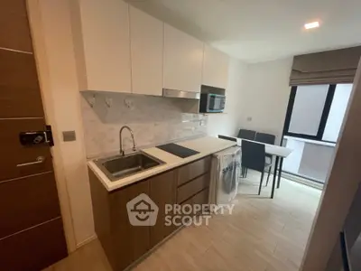 Modern kitchen with sleek cabinetry and dining area in stylish apartment
