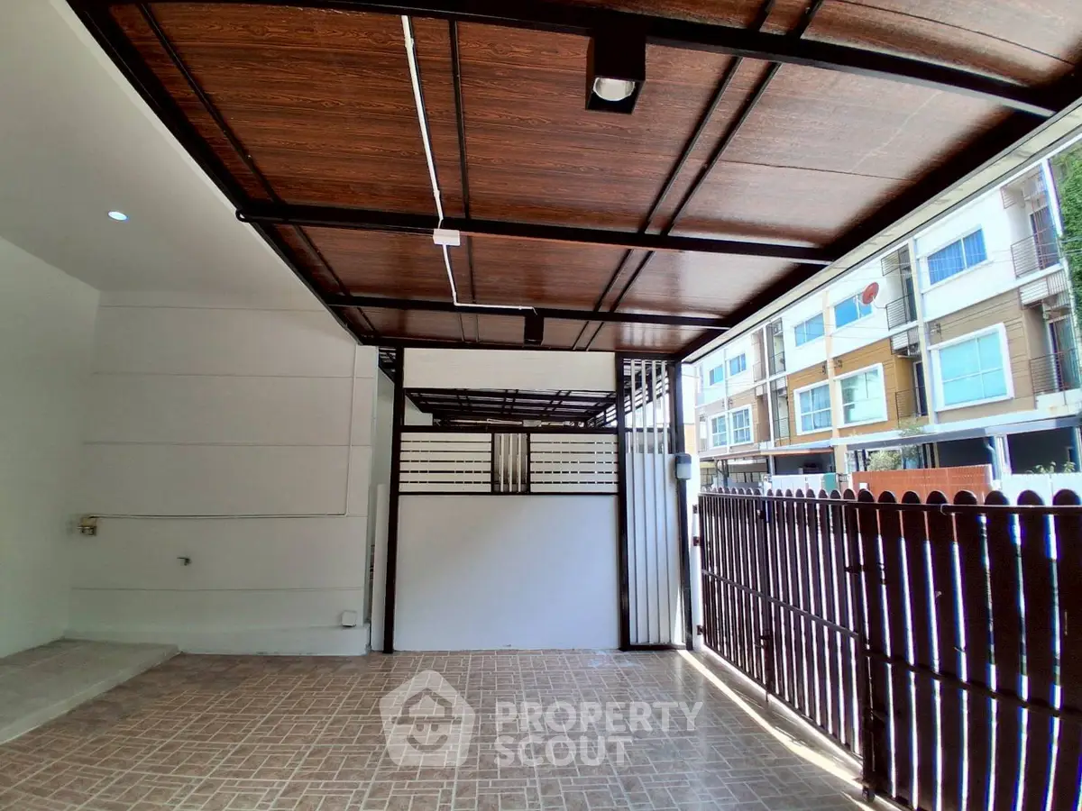 Spacious covered parking area with modern wooden ceiling and tiled flooring