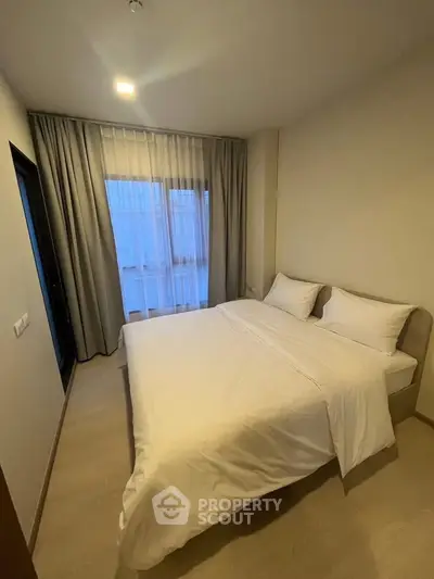 Cozy bedroom with modern decor and large window for natural light