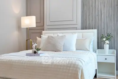 Elegant bedroom with modern decor, plush bedding, and stylish bedside lamp for a cozy ambiance.