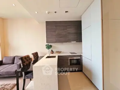 Modern open-layout kitchen with sleek cabinetry and cozy living area