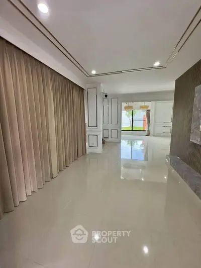 Spacious modern living room with elegant curtains and glossy tiled floor